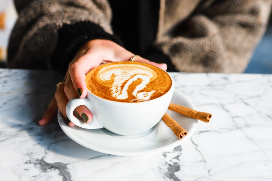 Cappuccino mit Schwan Latte Art mit Zimt auf einem Marmor Tisch