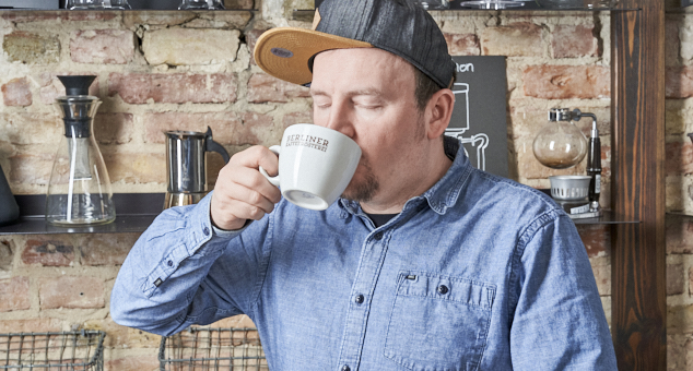 Mann genießt eine Tasse Berliner Kaffeerösterei Kaffee