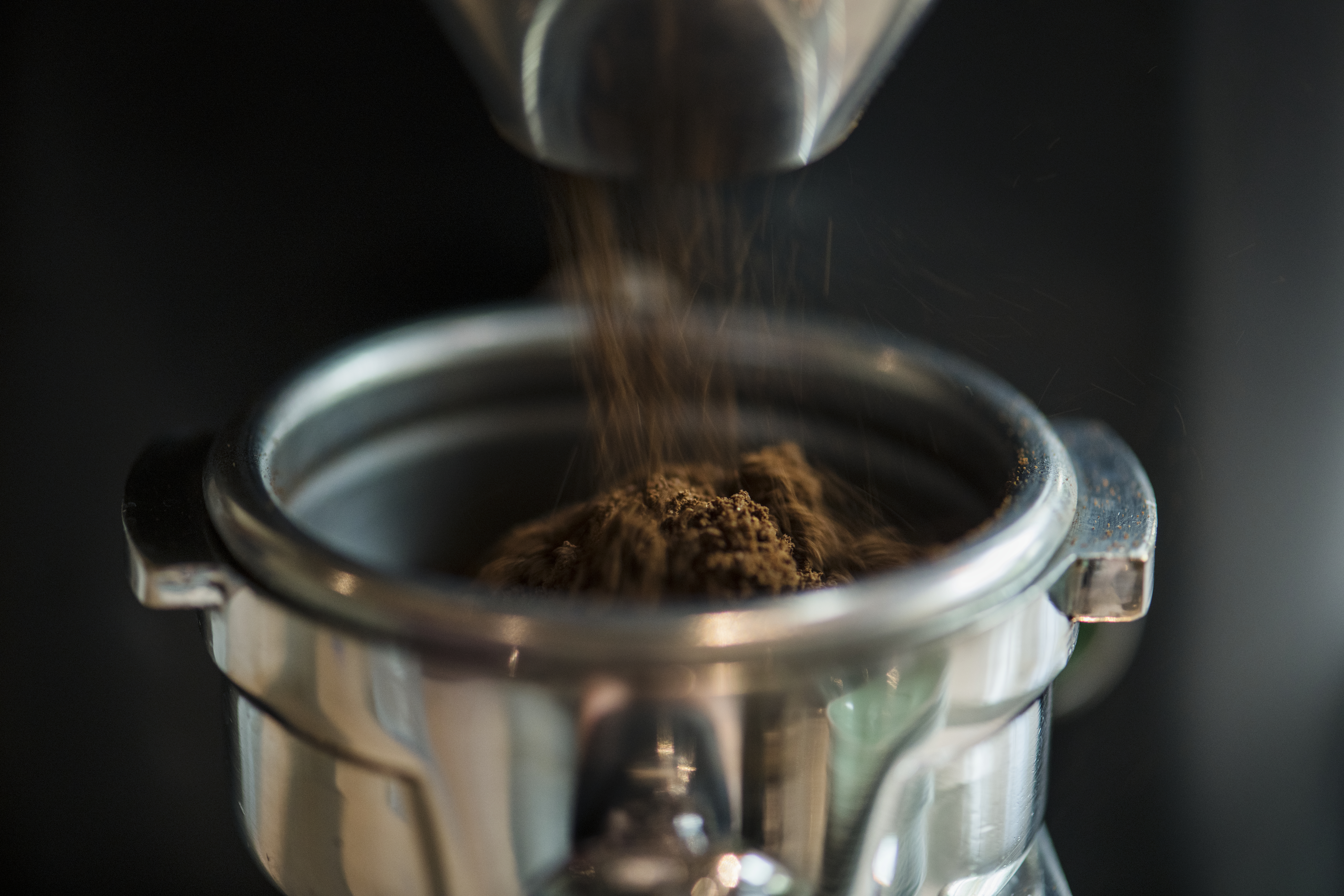 Closeup von frisch gemahlenem Kaffee in einem Siebträger - Hintergrund