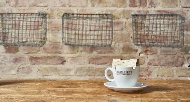Berliner Kaffeerösterei Kaffeetasse steht mit Aufgussbeutel auf rustikalem Tisch