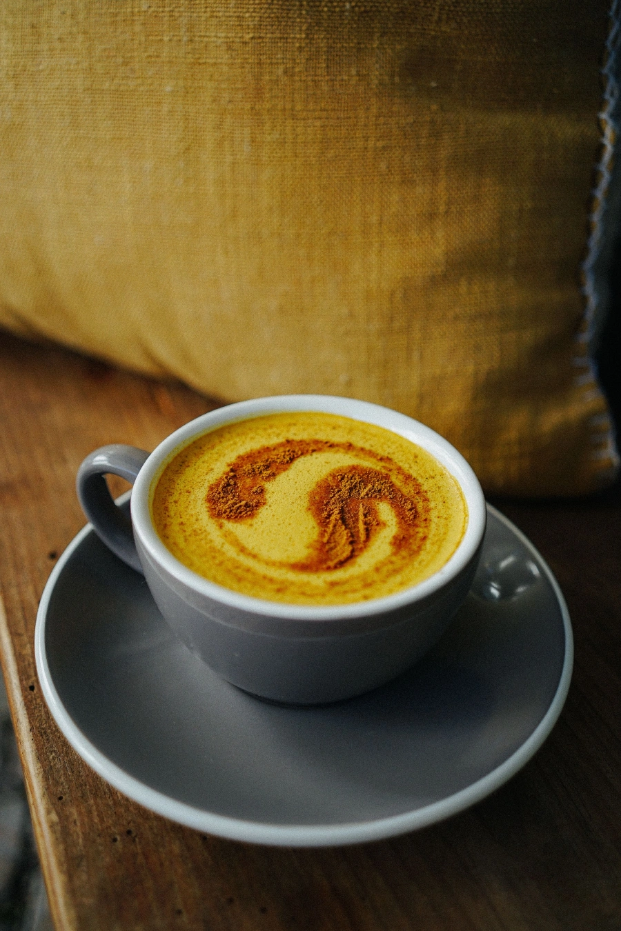Goldene Milch mit Zimt auf der Oberfläche in einer großen Tasse warm zu genießen