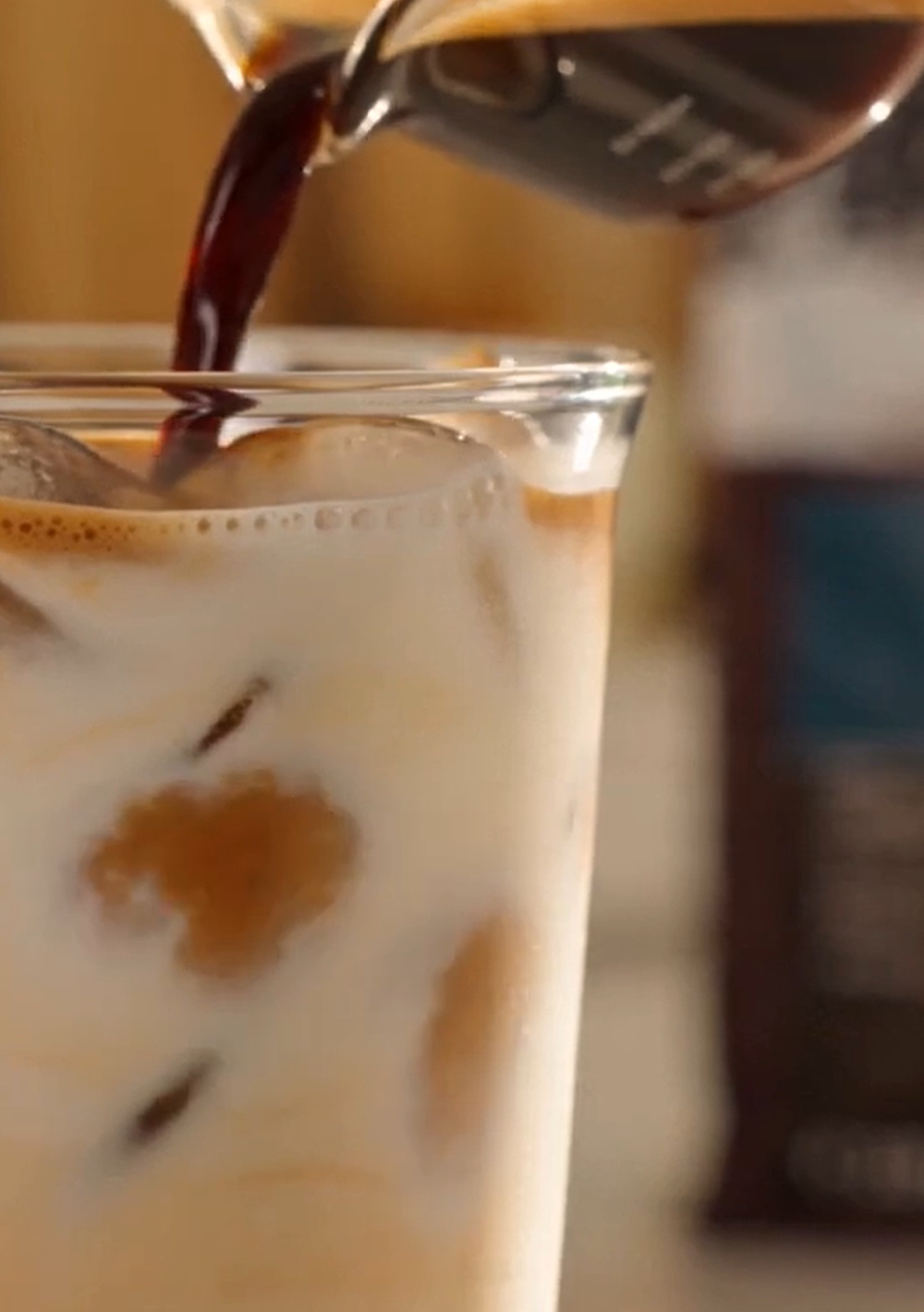Berliner Kaffeerösterei Kaffeerezept Eiskaffee Sommer mit Espresso und Eiswürfeln Iced Latte im Becher mit Strohhalm und Espresso