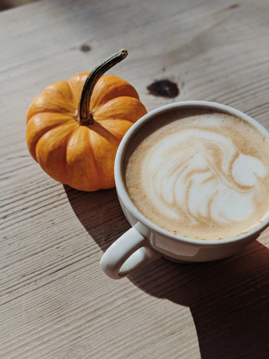 Pumpkin Spice Latte mit kleinem Kürbis als Dekoration