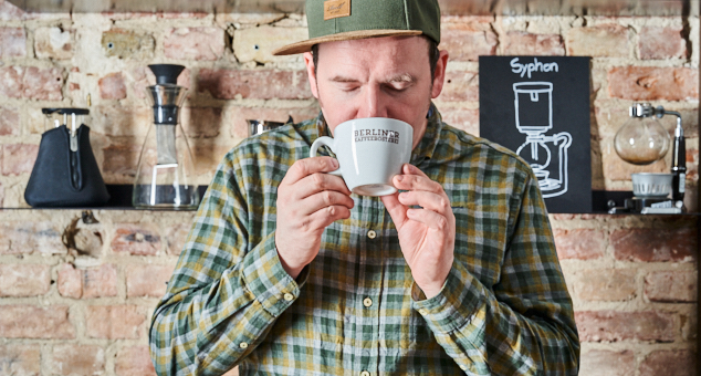 Mann trinkt Kaffee aus Berliner Kaffeerösterei Tasse